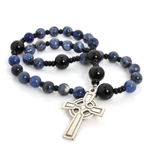 A string of round beads, featuring sodalite and onyx, with a silver Celtic Aura cross pendant at the center.